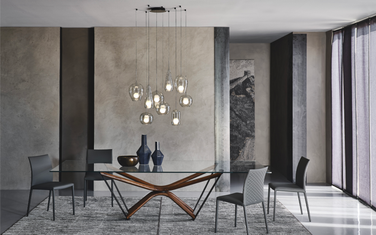 A modern dining area showcasing a glass table and chic chairs.