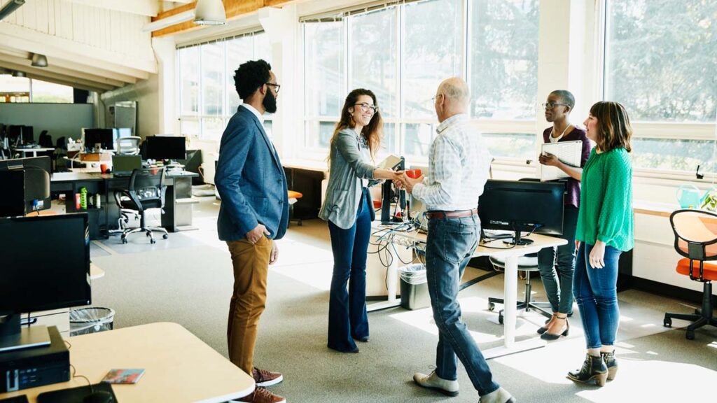 A diverse group of professionals standing in a modern office setting.