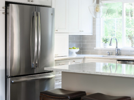 Bright and modern kitchen design created using Design Live by Justine Marie Designs. Features a white island countertop, stainless steel refrigerator, and gray tile backsplash with natural light streaming in through the window.