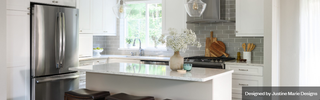 Bright and modern kitchen design created using Design Live by Justine Marie Designs. Features a white island countertop, stainless steel refrigerator, and gray tile backsplash with natural light streaming in through the window.