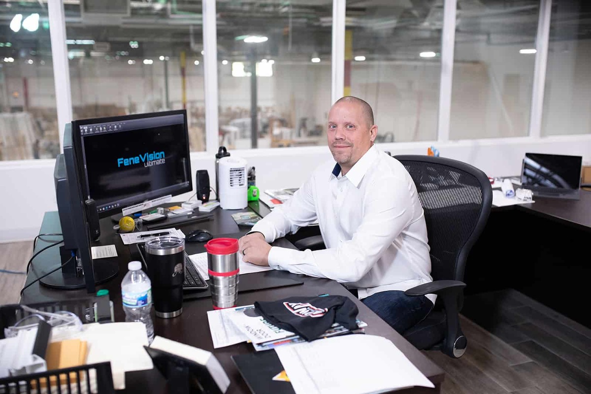 A man seated at a desk in a professional office environment