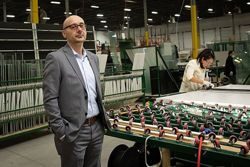 A well-dressed man stands before a machine