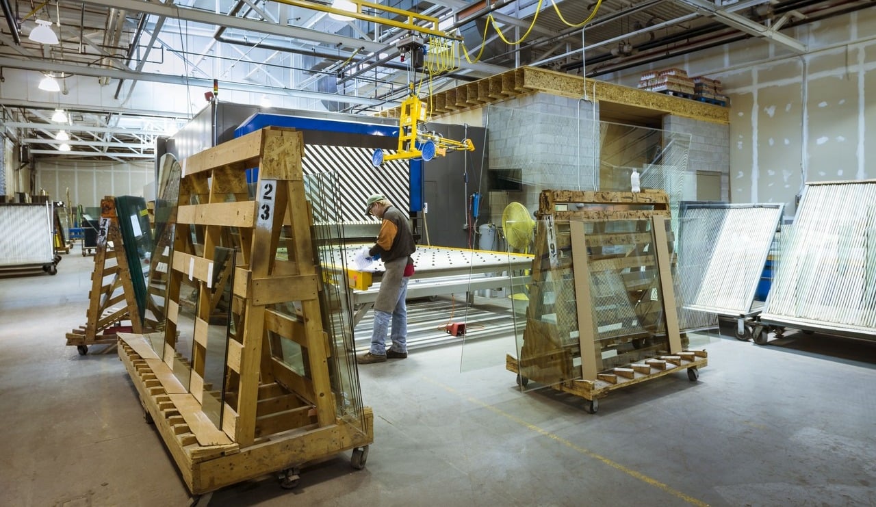 A man works in a warehouse filled with glass items