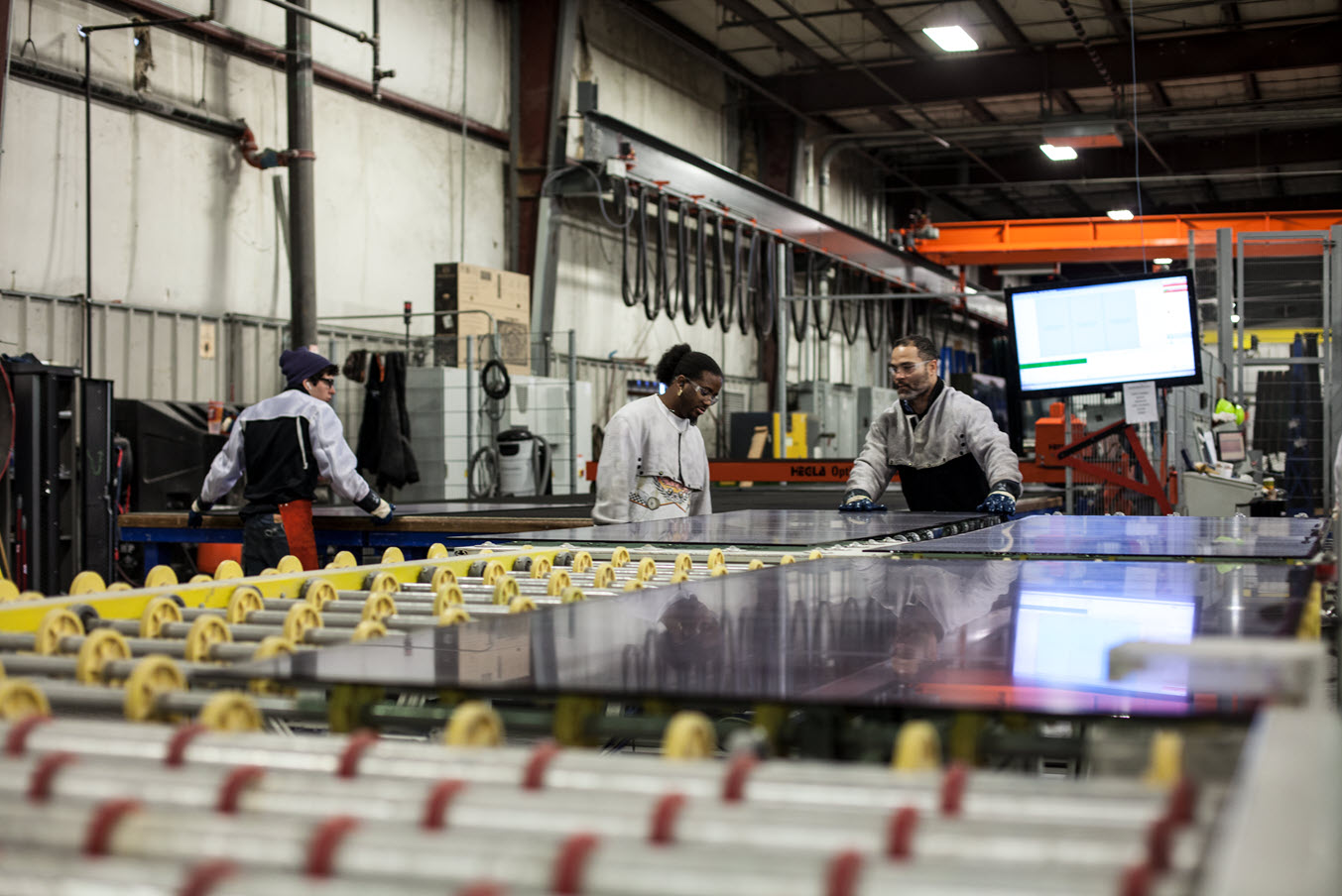 TriStar Glass workers collaborating on the production line, demonstrating FeneVision’s impact on operational efficiency.