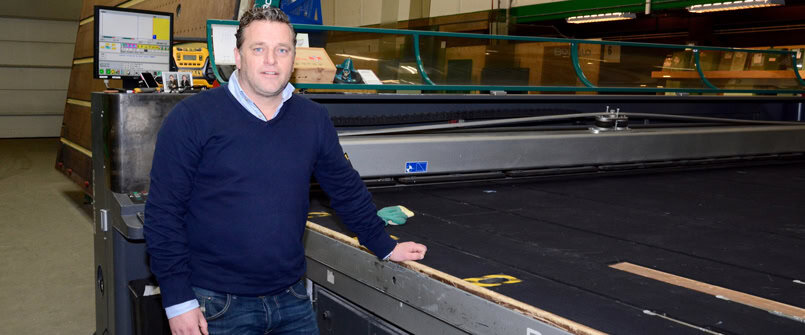 A man stands beside a large industrial machine