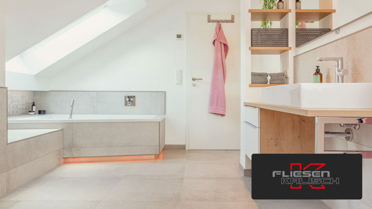 Stylish bathroom with an angled skylight, white bathtub, and natural wood accents designed by Fliesen Kalisch.