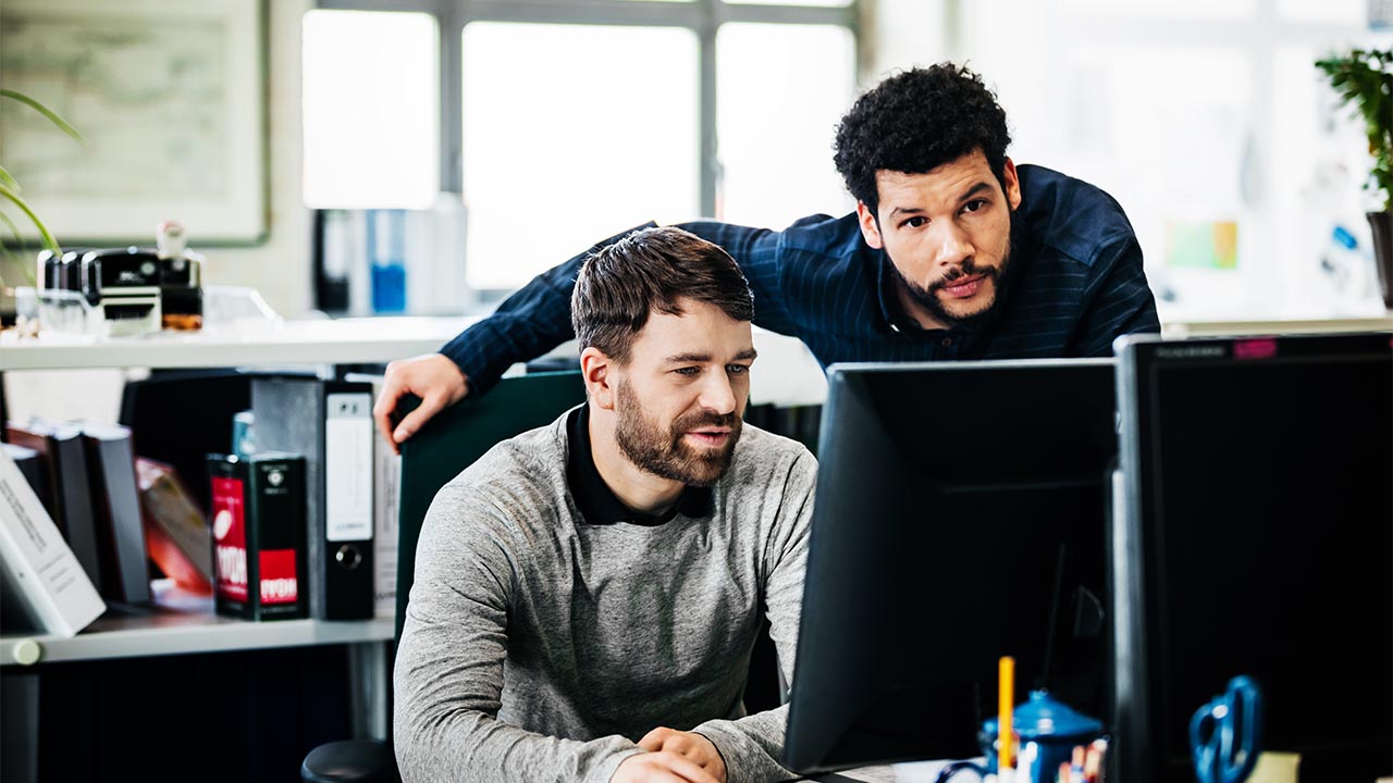 Two men focused on a computer screen